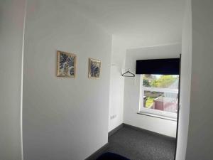 a room with two pictures on the wall and a window at Silver Stag Properties, Ensuite Bedrooms w Kitchen in Swadlincote