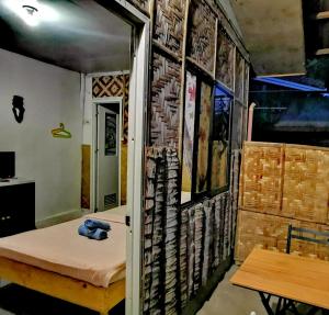 a room with a bed and a brick wall at Stay N Save B&B in Oslob