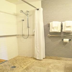 a bathroom with a shower with a curtain and towels at Distrikt Hotel New York City, Tapestry Collection by Hilton in New York