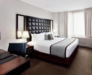 a hotel room with a large bed and a desk at Distrikt Hotel New York City, Tapestry Collection by Hilton in New York