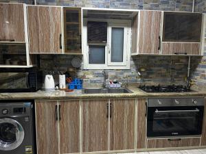 een keuken met houten kasten en een wastafel bij Budget Benefit Break in Alexandrië
