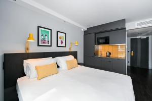 een slaapkamer met een groot wit bed met oranje kussens bij Staycity Aparthotels Heidelberg in Heidelberg