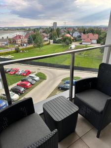 d'un balcon avec deux chaises et une vue sur le parking. dans l'établissement Apartament Sophie - Samozameldowanie - Self check-in, à Rzeszów