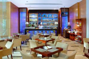 un restaurante con mesas y sillas y un bar en The Mayflower, Jakarta-Marriott Executive Apartments en Yakarta
