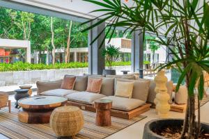 a living room with a couch and a table at Motto By Hilton Tulum in Tulum