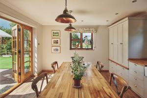 a dining room with a wooden table and chairs at Powk Meadow Farmhouse in Leominster