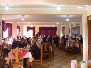 a group of people sitting at tables in a restaurant at Julia Plaza Hotel in Uyuni
