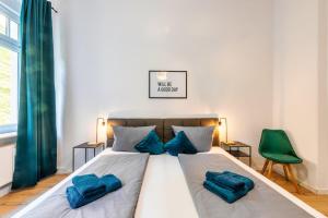 een slaapkamer met een groot bed met blauwe kussens bij unique Malterstraße feel-good-home - Dresden in Dresden