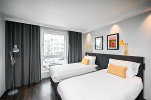 2 camas en una habitación de hotel con ventana en Staycity Aparthotels Heidelberg, en Heidelberg