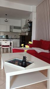 ママイアにあるApus De Soare Apartmentのリビングルーム(白いテーブル、赤いソファ付)