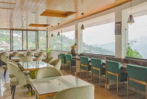 a restaurant with tables and chairs and windows at Days Inn by Wyndham Gangtok Tadong in Gangtok