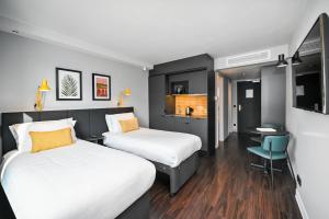 een hotelkamer met 2 bedden en een bureau bij Staycity Aparthotels Heidelberg in Heidelberg