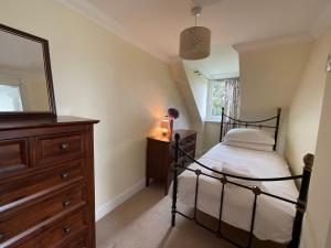 a bedroom with a bed and a dresser and a mirror at Blaeberry Cottage in Killean