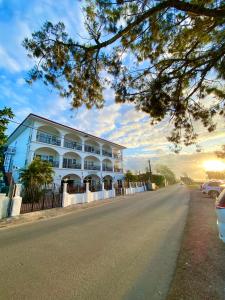 un grand bâtiment blanc sur le côté d'une route dans l'établissement Little Italy Hotel, à Nuku‘alofa