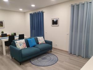 uma sala de estar com um sofá azul e uma mesa em Coração da Madeira em Curral das Freiras