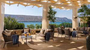 un patio con sillas y mesas y vistas al agua en Family Hotel Pagus - All Inclusive en Pag