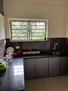 uma cozinha com um lavatório e uma janela em Sats residency em Sultan Bathery