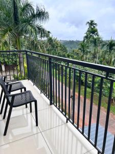 einen Balkon mit einem Stuhl und Waldblick in der Unterkunft Sats residency in Sultan Bathery