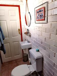 ein weißes Badezimmer mit Toilette und Waschbecken in der Unterkunft Collie Cottage in Clarens