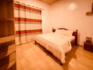 um quarto com uma cama e uma grande janela em BIZI HOMES, KABUGA 