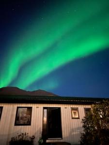 a house with the green northern lights in the sky at Cozy apartment in Seydisfjordur in Seyðisfjörður