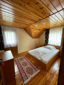 ein Schlafzimmer mit einem Bett und einer Holzdecke in der Unterkunft Cabana Med 2 in Arieşeni