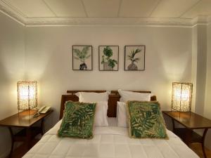 a bedroom with a bed with two lamps and two tables at Little Italy Hotel in Nuku‘alofa