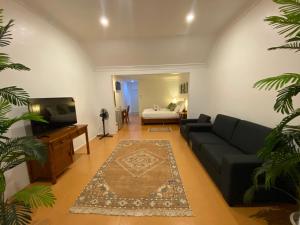 a living room with a couch and a tv and a bed at Little Italy Hotel in Nuku‘alofa