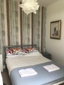 un letto in una camera da letto con lampadario a braccio di Golf View Cottage PORTRUSH a Portrush
