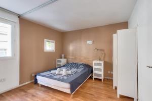 een slaapkamer met een bed en een witte kast bij Cosy studio à proximité du Parc Sergent Blandan in Lyon