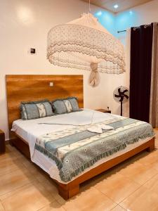 um quarto com uma cama grande e um lustre em BIZI HOMES, KABUGA 