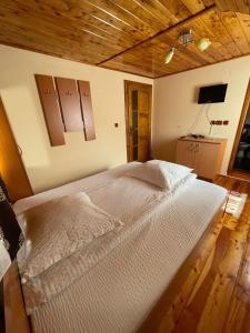 a bedroom with a large bed with a wooden ceiling at Cabana Med 2 in Arieşeni