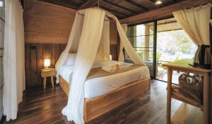 a bedroom with a bed with a mosquito net at อุ่นไอมาง สะปัน in Ban Huai Ti