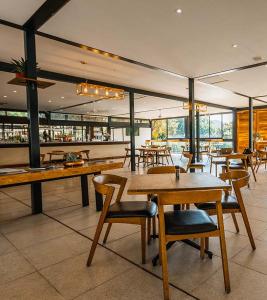 a restaurant with wooden tables and chairs and windows at Eye Of Africa Luxury Golf Suite in Eikenhof