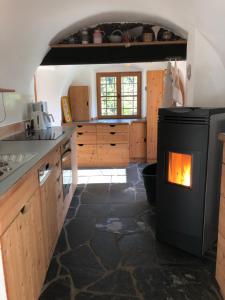 a kitchen with a stove with a fire in it at Klösterle Haus Resi in Arriach