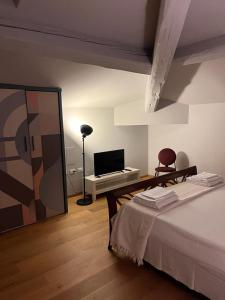 a bedroom with a bed and a tv and a mirror at Casa Cavour in Montecatini Terme