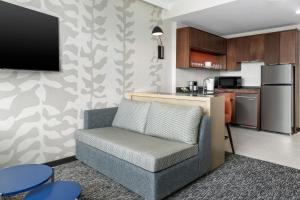 a living room with a couch and a kitchen at Residence Inn by Marriott New York Queens in Queens