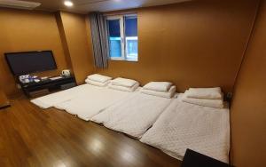 a bedroom with two beds and a flat screen tv at Soosong Guesthouse in Seoul