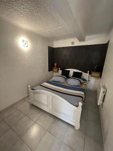 ein Schlafzimmer mit einem weißen Bett mit einem schwarzen Kopfteil in der Unterkunft PASSION DU VAR in Vidauban