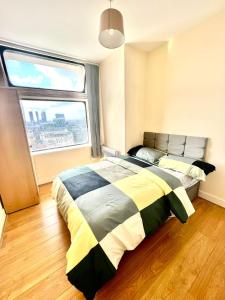 ein Schlafzimmer mit einem Bett und einem großen Fenster in der Unterkunft Two Bedroom apartment with Kitchen Facility in Manchester