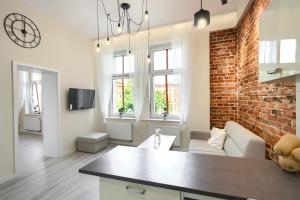 uma cozinha e sala de estar com uma parede de tijolos em APARTAMANT DE LUX em Kluczbork