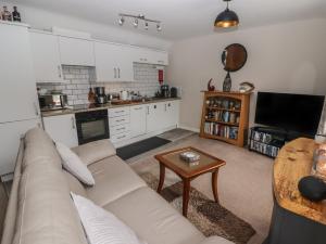 a living room with a couch and a table at Daffodil Apartment in Tenby