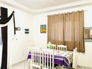 a room with a crib and a table and chairs at Casa espaçosa com Piscina e Churrasqueira 2 dorm in Guarujá