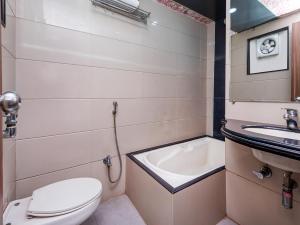 a small bathroom with a toilet and a sink at HOTEL BALWAS in Surat