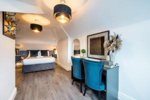um quarto com uma cama e uma secretária com cadeiras azuis em Host & Stay - The Kensington Townhouse em Liverpool