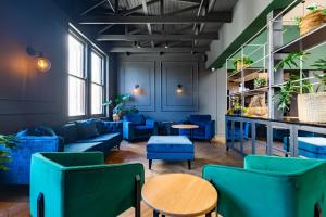 a room with blue couches and tables and plants at Old Bank Hotel - Lion Roars Hotels & Lodges in Cape Town