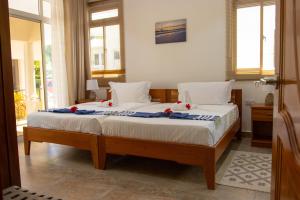 ein Schlafzimmer mit einem Bett mit roten Blumen darauf in der Unterkunft Macmillan's Holiday Villas in Grand'Anse Praslin