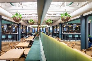 a restaurant with wooden tables and chairs and potted plants at Old Bank Hotel - Lion Roars Hotels & Lodges in Cape Town