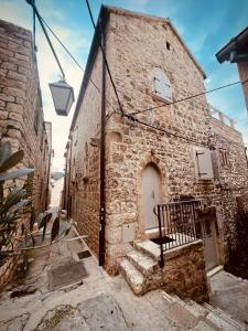 ein Steingebäude mit einer Bank davor in der Unterkunft Fortezza - Hvar Old Town Apartment in Hvar
