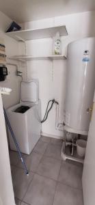 eine kleine Küche mit einem Kühlschrank, einer Waschmaschine und einem Trockner in der Unterkunft PASSION DU VAR in Vidauban